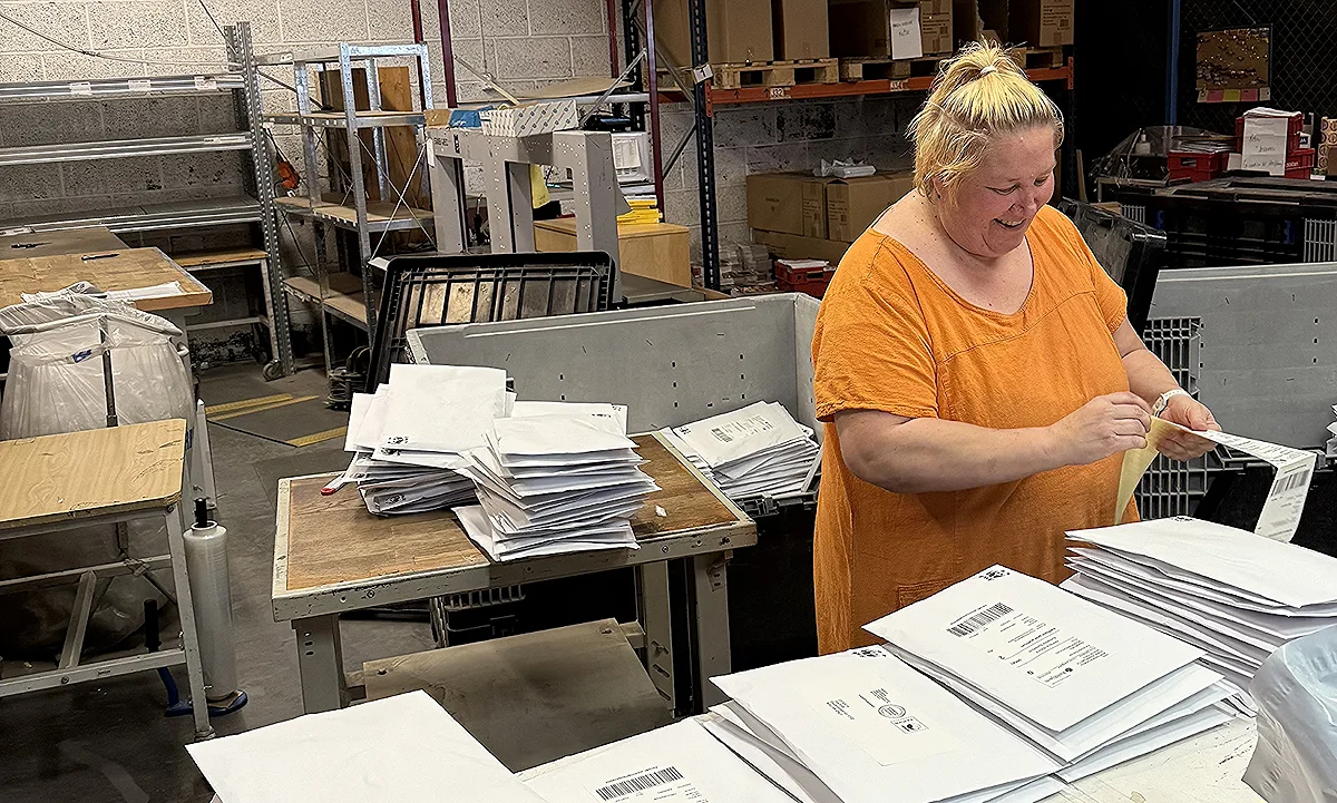 Manuell pakking utført av smilende kvinnelig kollega i Aksell logistikk