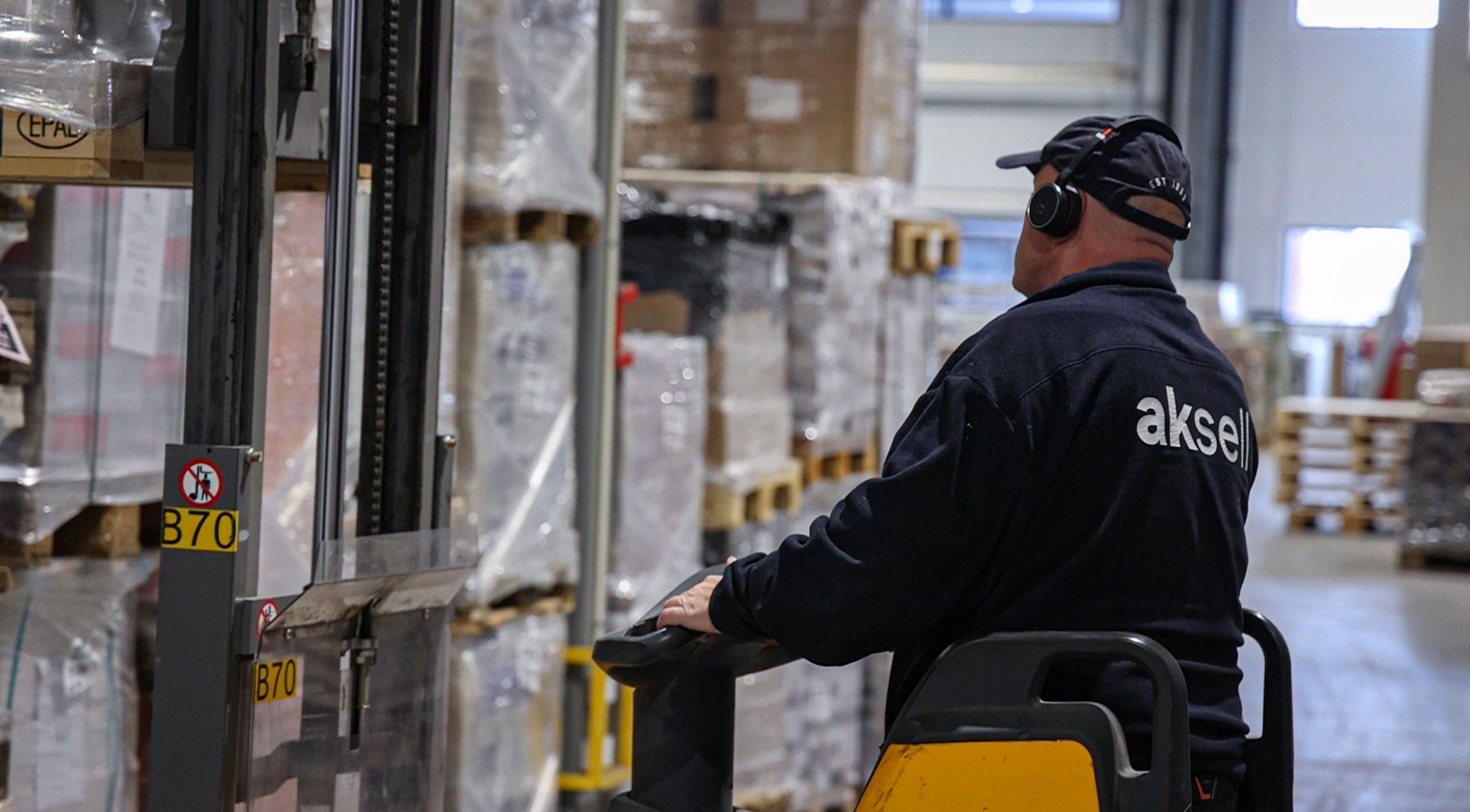 Mann losser varer med gaffeltruck hos Aksell Logistikk